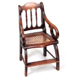 A 19TH CENTURY STAINED FRUITWOOD CHILD'S CHAIR with spindle back, scrolled arms and caned seat;