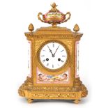 A 19TH CENTURY FRENCH ORMOLU AND SEVRES PORCELAIN PANELLED MANTEL CLOCK the ornate bow-sided case on