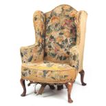 A 19TH CENTURY QUEEN ANNE STYLE WALNUT WINGBACK ARMCHAIR with tapestry upholstery, shaped back and