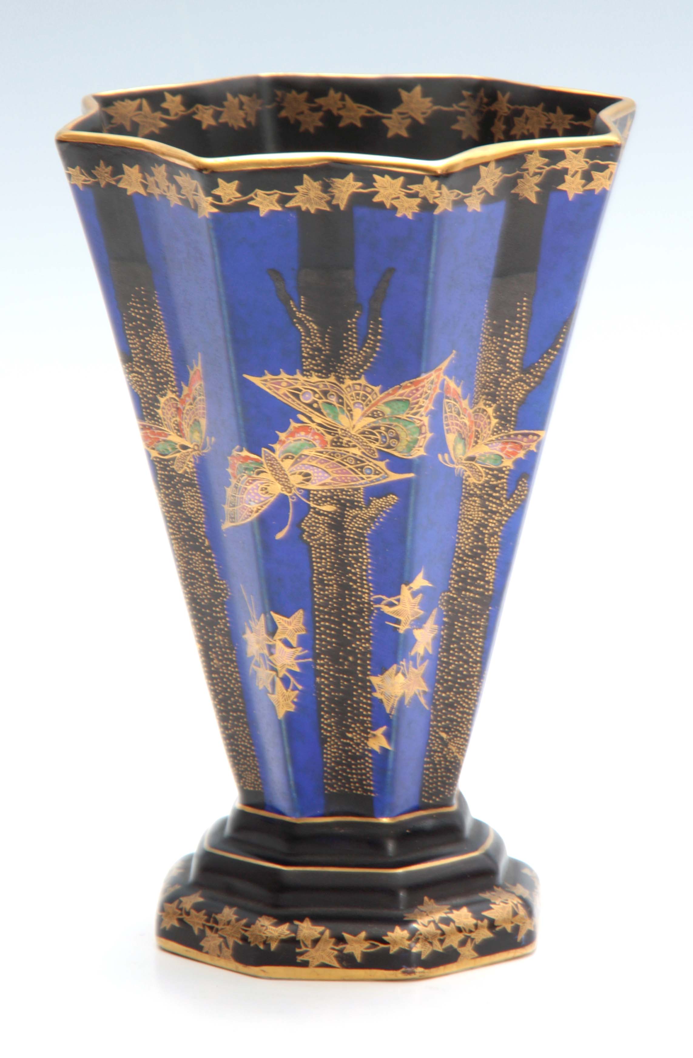 A CROWN DEVON FIELDINGS FLARED FOOTED VASE of octagonal panelled form, royal blue and black ground