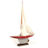 AN EARLY 20TH CENTURY WOOD POND YACHT with weighted keel and large sails 123cm wide 188cm high