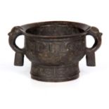 AN EASTERN CAST BRONZE CENSOR with lion's head side handles and decorated reliefwork swags 16cm wide