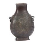AN EARLY ANTIQUE CHINESE CAST BRONZE MOON VASE with relief work dragon to the front and reverse,