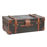 AN EARLY 20TH CENTURY CANVAS AND LEATHER TRAVELLING TRUNK BY FINNIGANS the strapwork stamped with