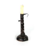 AN 18TH CENTURY SPIRAL STEM IRONWORK PIGTAIL CANDLESTICK with adjusting candle ejector and ringed