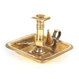 A GEORGIAN RECTANGULAR BRASS SIDE HANDLED CHAMBER CANDLESTICK with deep tray base; fitted candle