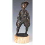 A STYLISH EARLY 20TH CENTURY PATINATED BRONZE SCULPTURE modelled as a young jockey with hands in his