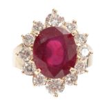 A LADIES 14ct GOLD RUBY AND DIAMOND RING having a 7ct oval brilliant-cut ruby surrounded by 12