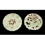 TWO CHINESE CARVED PIERCED JADE PI DISCS one formed a Foo dog with leaf work surround 54mm diameter,