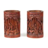 A PAIR OF JAPANESE CARVED BAMBOO BRUSH POTS decorated with figures in woodland settings 15.5cm high
