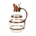 AN ART AND CRAFTS COPPER BOUND GLASS CLARET JUG with hinged spout, wooden bound side handle and