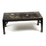 A LACQUERED COFFEE TABLE with a floral decorated top; standing on square legs with pierced corner
