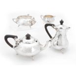 A SILVER ARTS & CRAFTS DESIGN FOUR-PIECE TEA SERVICE having planished bodies and ebonized handles,