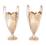 A STYLISH PAIR OF ART NOUVEAU SILVER-GILT RAISED TWO HANDLED PEDESTAL VASES the scalloped rims