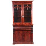 A 19TH CENTURY FLAME MAHOGANY SECRETAIRE BOOKCASE having a moulded cornice above gothic style glazed
