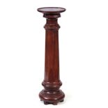 A 19TH CENTURY MAHOGANY TURNED PEDESTAL with moulded top above a ring turned column; standing on bun