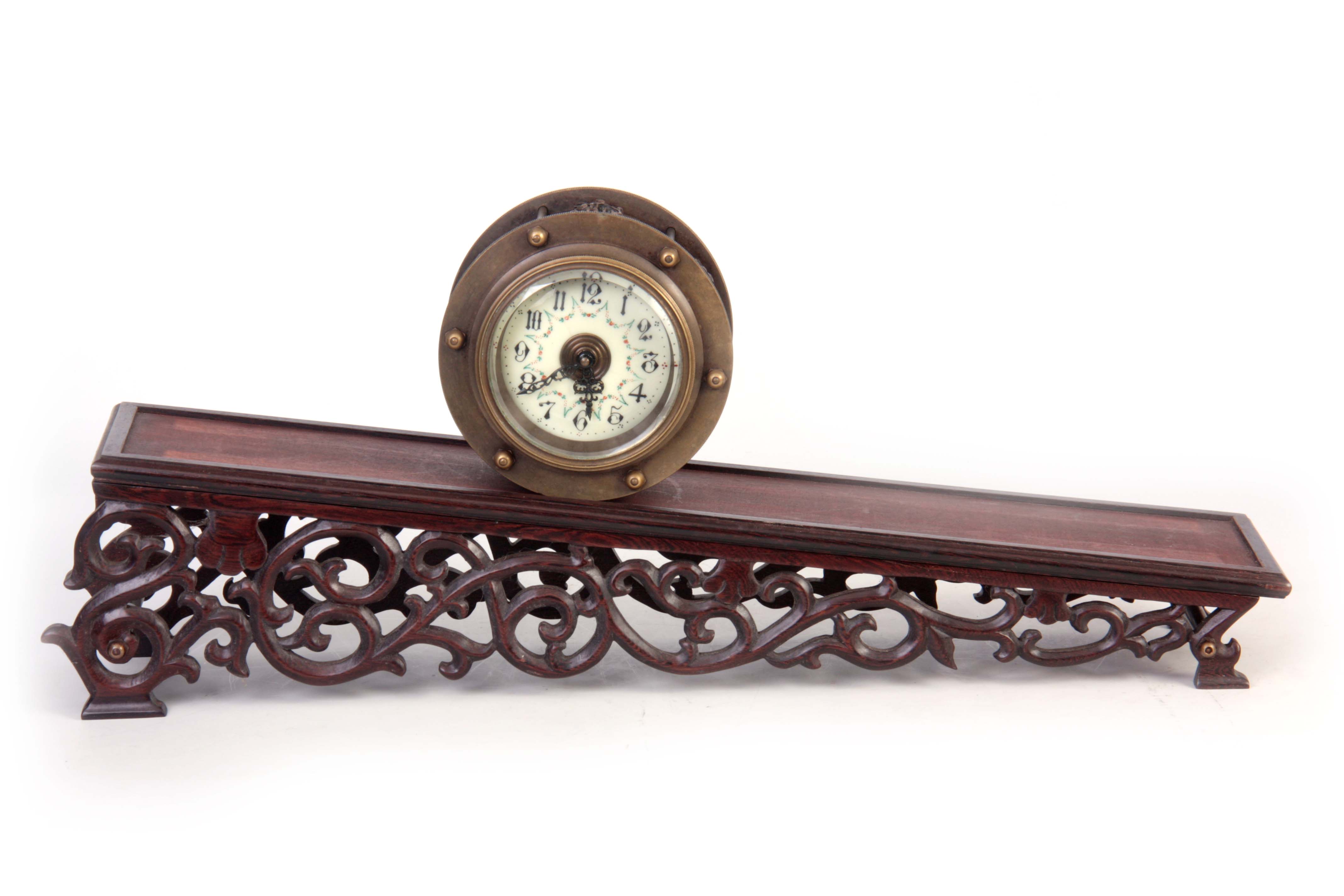 A BRASS CASED INCLINE GRAVITY CLOCK with drum-shaped case enclosing a porcelain dial with Arabic