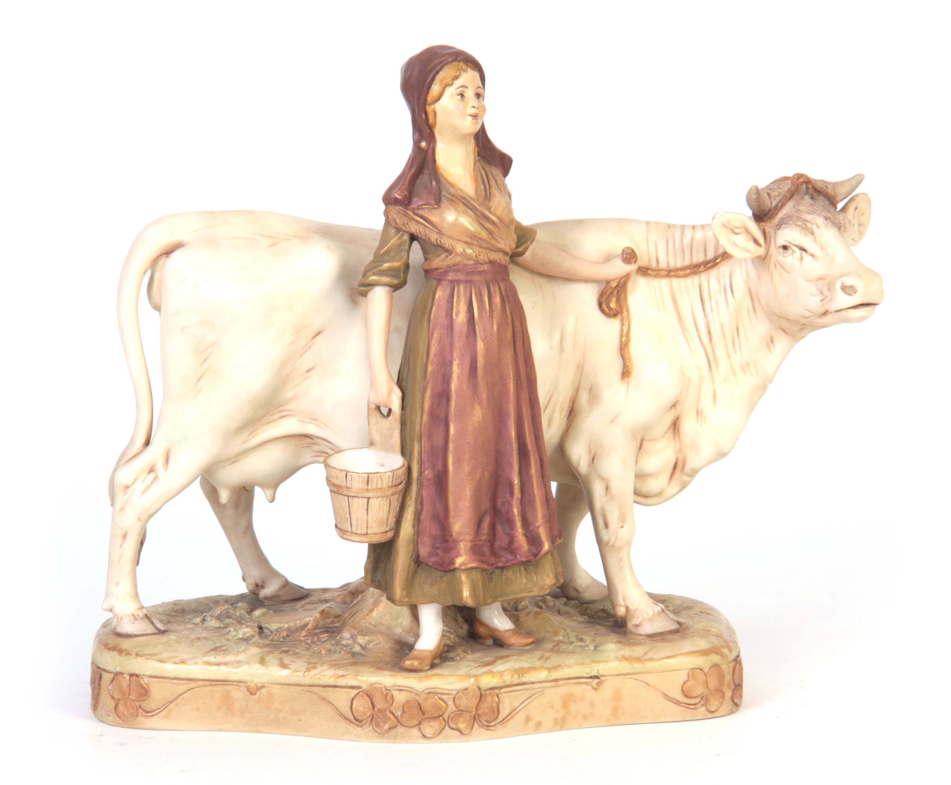 A ROYAL DUX BOHEMIA ANIMAL FIGURE modelled as a dairy cow and standing milk maid coloured in soft