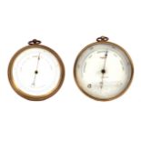 TWO EARLY 20TH CENTURY ANEROID BAROMETERS in circular brass cases enclosing calibrated white