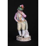 A 19TH CENTURY MEISSEN STANDING BOY FIGURE depicted next to a marbled column and wearing classical
