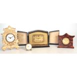 A COLLECTION OF FOUR CLOCKS comprising a gilt brass art deco alarm clock in fitted case 14cm wide,