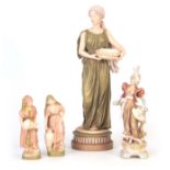 A GROUP OF FOUR ROYAL DUX STANDING FIGURINES comprising a Tall Classical Maiden holding a shallow