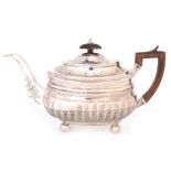A GEORGE III SILVER TEAPOT of rectangular decorative design on four ball feet with hinged lid and
