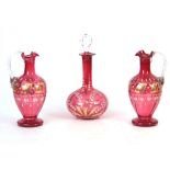 A PAIR OF VICTORIAN CRANBERRY DECANTERS with gilt panelled enamelled flower spray decoration to