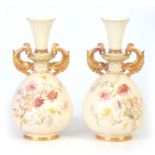 A LARGE PAIR OF ROYAL WORCESTER ORNATE GILT TWO-HANDLED IVORY GROUND VASES of bulbous footed form