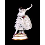 A CONTINENTAL STANDING FIGURE OF A BALLET DANCER dressed a finely detailed meshwork costume set with