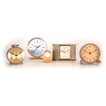 A COLLECTION OF FIVE BRASS TRAVELLING CLOCKS to include a Zenith alarm clock, four with spring