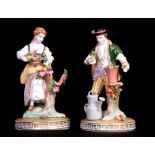 A PAIR OF DRESDEN CLASSICAL GARDENER AND FLOWER SELLER FIGURES colourfully dressed in classical