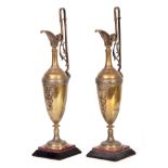 A PAIR OF LATE 19TH CENTURY BRONZE EWERS ON SLATE AND ROUGE MARBLE BASES decorated with the Staff of