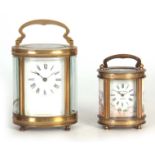 TWO 20TH CENTURY FRENCH OVAL CASED CARRIAGE CLOCKS the larger having an enamel Roman dial fronting