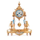 A LATE 19TH CENTURY FRENCH GILT BRASS AND PORCELAIN MANTEL CLOCK supported on four columns flanked