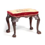 A 19TH CENTURY MAHOGANY CHIPPENDALE STYLE STOOL OF SERPENTINE OUTLINE with leaf carved cabriole legs