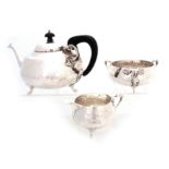 A GEORGE V ART NOUVEAU STYLE THREE-PIECE SILVER TEA SERVICE of planished design comprising a three