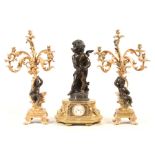 A MONUMENTAL BRONZE AND ORMOLU FIGURAL CLOCK GARNITURE the clock surmounted by a patinated bronze