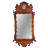 A GEORGE I FIGURED WALNUT AND GILT WORK HANGING MIRROR with shaped frame, carved crest and flower