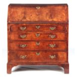 AN EARLY 18TH CENTURY FIGURED WALNUT BUREAU with herringbanded inlay, the angled fall opening to