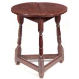 A GEORGE I OAK CRICKET TABLE OF SMALL SIZE with circular top above a tripod turned base joined by