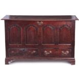 A MID 18TH CENTURY OAK MULE CHEST with hinged top above arched fielded panels and bottom drawers; on