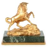 A 20TH CENTURY GILT BRONZE FIGURE depicting a mythical creature mounted on a green marble base