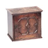 A WILLIAM AND MARY OAK HANGING SPICE CUPBOARD with geometrically moulded hinged door enclosing a