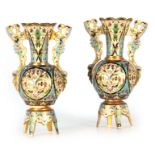 A PAIR OF 19TH CENTURY CHAMPLEVE ENAMEL VASES with shaped side handles and bulbous bodies;