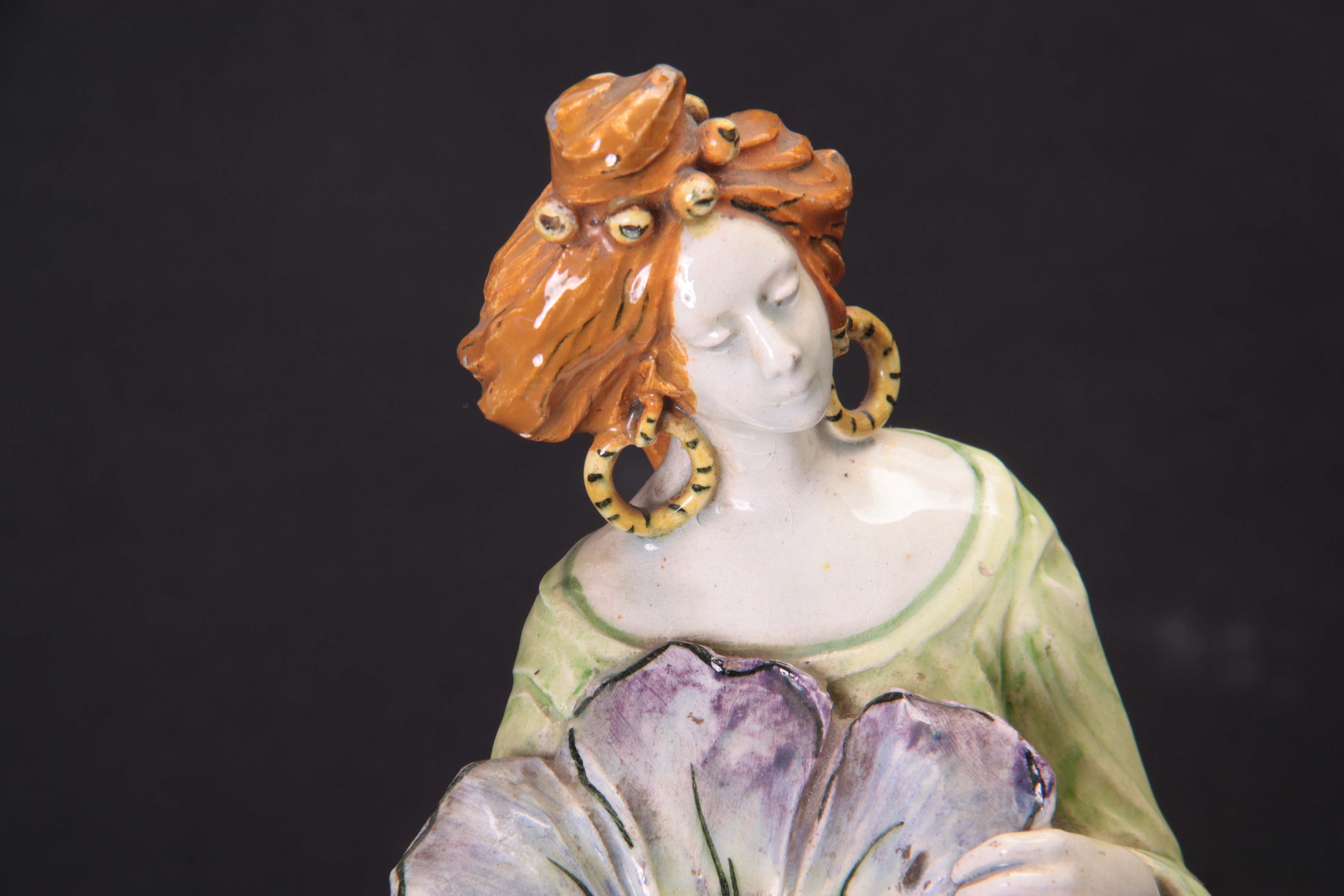 AN ART NOUVEAU GLAZED POTTERY FIGURE modelled as a standing lady clutching a flower head with hollow - Image 3 of 5