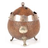 A 19TH CENTURY COCONUT CADDY with silver metal mounts and raised splay feet, the domed lid with