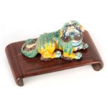 A 19TH CENTURY GLAZED POLYCHROME SMALL RECUMBENT MODEL OF A FOO DOG 10.5cm wide - impressed seal