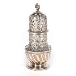 A VICTORIAN SILVER SUGAR CASTER with embossed foliate decoration, spiral fluted base and gilt