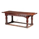 A 17TH CENTURY OAK REFECTORY TABLE with plank top above a carved joined base with cup and cover